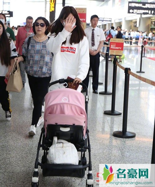 张子萱带女儿现身机场 打扮低调挡脸防拍